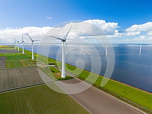 A mesmerizing aerial view of a wind farm near the ocean, where rows of elegant windmill turbines catch the breeze