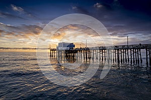 Mesmerizing scene of the pier at Newport Beach under sunset dramatic sky, California