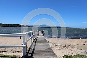 Mesmerizing shot of  Culburra Beach, South Coast, Australia with a bridge under the clear sky