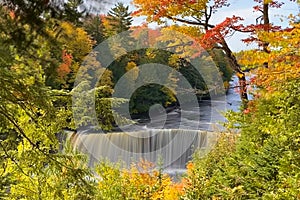 Mesmerizing Tahquamenon Falls waterfall in Michigan captured through autumn foliage, fall colors