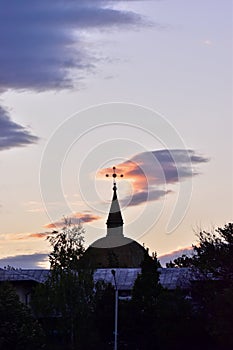 Mesmerizing view of a church tower with a cross on top at sunset in Lasi, Romania