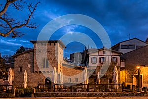 Meson del Caballo Blanco surrounded by lights under a cloudy sky in the evening in Spain