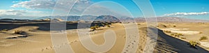 Mesquite Sand Dunes, mountains and cloudy sky background, panoramic view. Death Valley National Park