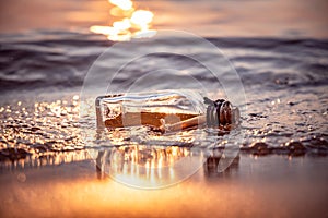 Message in the bottle against the Sun setting down