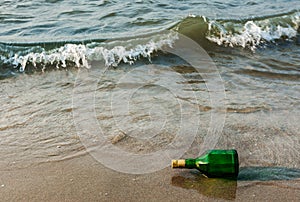 Message bottle on beach in waves