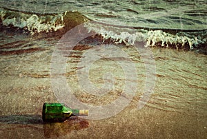Message bottle on beach in waves