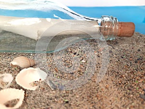 Message in a Bottle. Decorative background with a bottle on the sand with a sheet of paper for posting. 