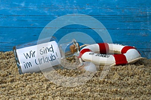 Message in a bottle with the german words for we are on holiday - wir sind im urlaub photo