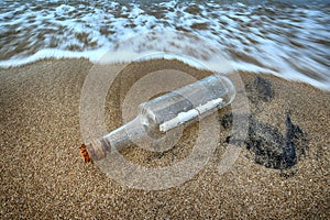 Message in a bottle in the sand of sea beach