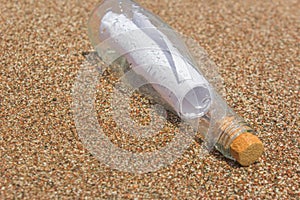 A message in a bottle on the sand. note on salvation, please help