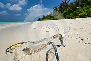 Message in a bottle washed ashore on a tropical beach.