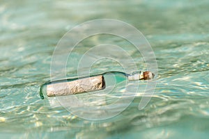 Message in a bottle washed ashore on tropical beach. photo