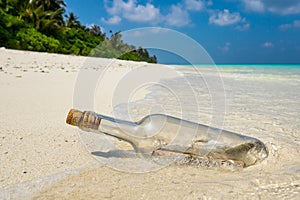 Message in a bottle washed ashore on a tropical beach