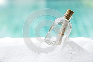 Message bottle on white sand