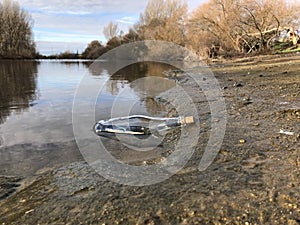 Message in a crystal bottle in the beach with water and sand