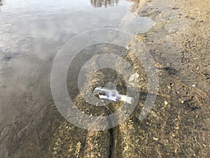 Message in a crystal bottle in the beach with water and sand