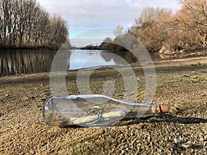 Message in a crystal bottle in the beach with water and sand