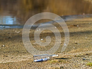 Message in a crystal bottle in the beach with water and sand