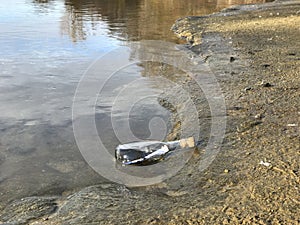 Message in a crystal bottle in the beach with water and sand