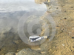 Message in a crystal bottle in the beach with water and sand