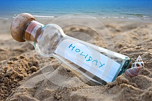 Message in glass bottle on sand with seascape background