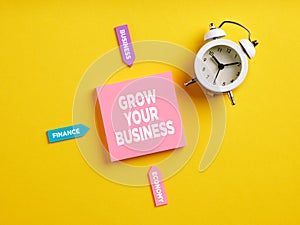 The message grow your business on pink note paper. Business growth, improvement and advancement process