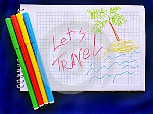 Message Lets Travel on white notebook with color markers. Closeup. Travel concept.