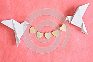 Message of pure love concept. Two white dove origami carrying heart shape on red background.