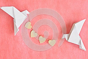 Message of pure love concept. Two white dove origami carrying heart shape on red background.