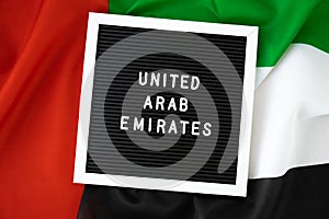 Message UNITED ARAB EMIRATES on background waving flag of UAE. National holiday, Independence Commemoration Day Muslim