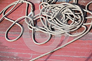 messed up sisal rope lying on red boat deck photo