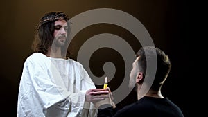 Messiah and praying man holding candle, faith in God, religious hope, blessing