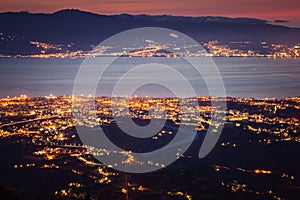 Messina strait and Reggio Calabria city lights at dusk