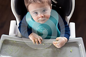Messy baby boy eating avocado