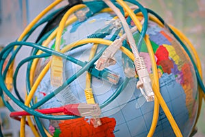 A messy cable plexus is on the world map. Many of tangled internet wires entangle around the globe. The Internet network covers