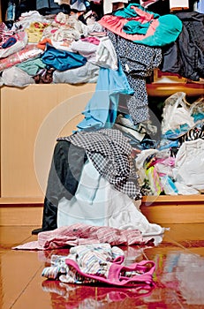 Messy disorder clothes over the closet. Untidy cluttered woman c