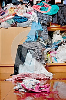 Messy disorder clothes over the closet. Untidy cluttered woman c photo