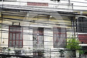 Messy electric wiring, a tangled mass of exposed cables on a street in Hanoi, Vietnam