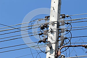 Messy electrical cables and wires on electric pole on clear blue sky background