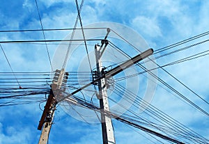 The Messy electrical cables and wires on electric pole on sky background