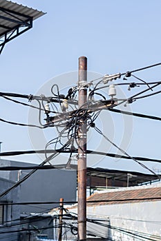 messy electricity wires on the pole. Pole with a large number and chaotic intertwined electrical cables