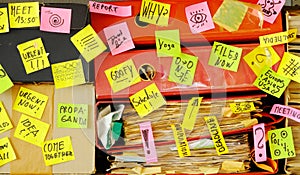 Messy file folder,sticky notes and old papers.Red tape, bureaucracy,overworked,burn out,exploitation,messy office and chaotic