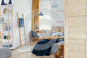 Messy kid`s bedroom with toys and wooden furniture real photo