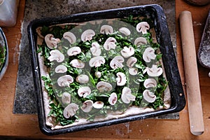 Messy kitchen benchtop with food preparation - home baking vegetarian pizza