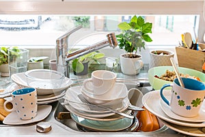 Messy kitchen counter with pile of dirty dishes in sink - Compulsive Hoarding Syndrome photo