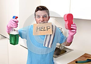 Messy man in stress in washing gloves holding sponge and detergent spray bottle asking for help