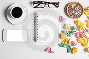 Messy office table with empty smartphone