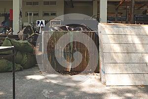 Messy Outdoor Studio Garage/ Backyard/ JunkYard with Rusty Old Zinc Doors, White Painted Woods and Green Industrial Sacks