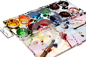 Messy palette with watercolor paints on the white  background, acrylic paints for drawing, bright colorful abstract