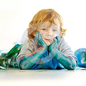 Messy, portrait and a child in paint after art in class, school or education on the floor. Happy, relax and a boy, kid